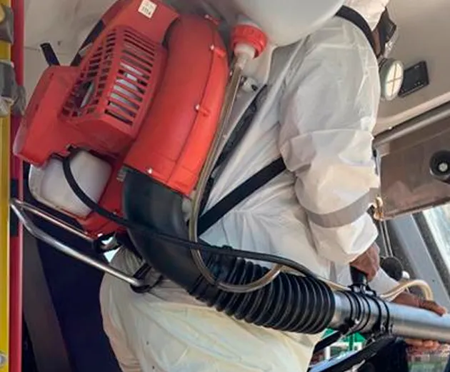 Técnico con traje protector aplicando sanitización con nano cobre en el interior de un bus
